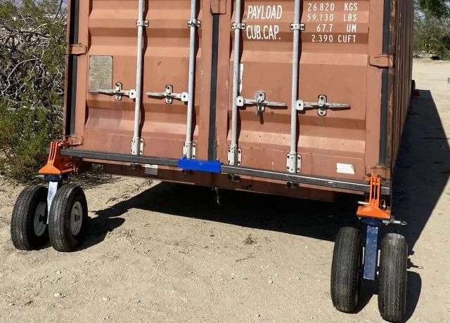 Orange trailer with payload information and wheels outdoors.
