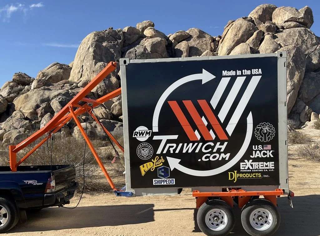 Mobile billboard by rocky terrain under clear sky.