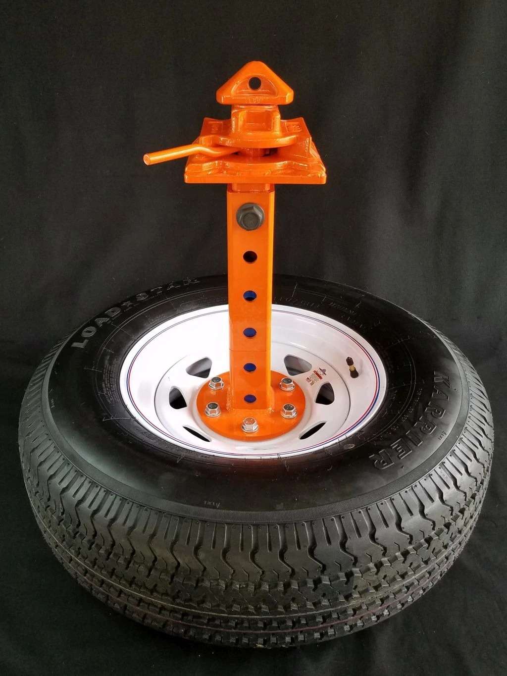 Car wheel with orange bead breaker tool.