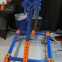 Blue and orange engine hoist in workshop.