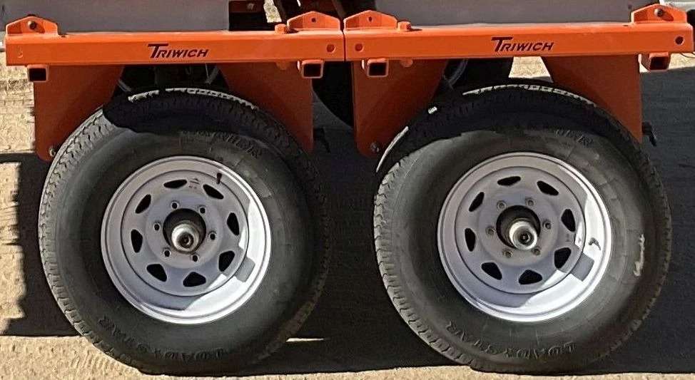 Orange trailer dual wheels close-up.